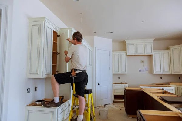 Guy repairing cabinet